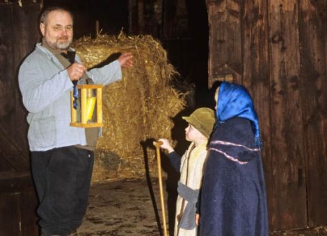 Ein Wirt zeigt Maria und Josef ihr Lager - einen Stall