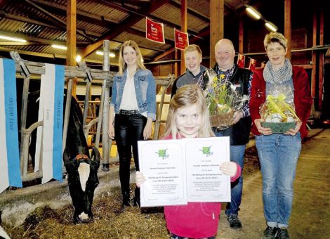 Mit Lena und Gerry wurde in Dainrode bei Frankenau im Landkreis Waldeck-Frankenberg vorletzte Woche die Familie Olaf Fackiner für zwei Kühe ihrer „Birkenhof Holsteins“ mit einer Leistung von über 100 000 Liter ausgezeichnet. Dabei beträgt die Lebensleistung von Lena 100 000 kg und die ihrer Stallgenossin Gerry sogar 120 000 kg Milch. „Die Kühe sind ein Zeichen dafür, dass Tierwohl eine große Rolle spielt“, so Jens Wiesemann von der Bezirksgruppe der Rinder­züchter Frankenberg. Die beiden 13-jährigen Kühe seien eine Auszeichnung für die „züchterische und betriebliche Leistung“ auf dem Birkenhof, betonte er. Für die Zucht- und Besamungsunion Hessen gratulierte Klaus Lerch aus Rosenthal und überreichte die Ehrenschleifen. „Ich habe natürlich den beiden Kühen zu danken“, betonte Olaf Fackiner. Der Landwirt hat den Betrieb seiner Eltern im Jahr 2000 übernommen und seitdem stetig vergrößert und auf den neuesten technischen Stand gebracht. Das Wohl der Tiere liege ihm am Herzen, denn nur mit gesunden Tieren könne er gute Leistungen erreichen und seine wirtschaftliche Existenz sichern. Tierwohl auf dem Birkenhof bedeute, „mit Stroh eingestreute Liegeboxen, viel Licht und frische Luft im Stall, saubere Laufgänge sowie ausgewoge­nes, der Leistung ange­passtes Futter“, sagte der Landwirt. Insgesamt hält der Betrieb 300 Milchkühe der Rasse Holstein und Jersey. Dazu kommen 180 Jungrinder und vier Zuchtbullen. Im vergangenen Jahr ist eine Biogasanlage in Betrieb genommen worden, teilte er den etwa 100 Besuchern bei der Hofführung mit. Das Foto zeigt die Züchterfamilie mit den Betriebsleitern Olaf und Heike Fackiner mit Sarah, Fabian und vorne Pia Fackiner. Text/Foto: Susanna Battefeld