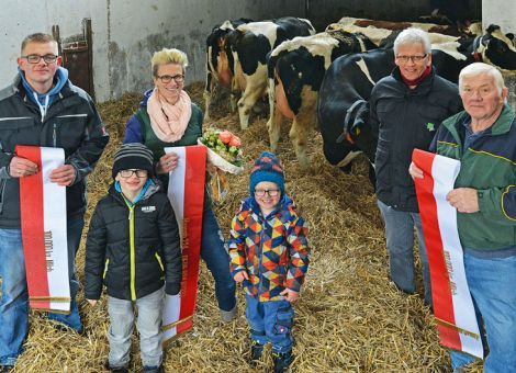 Dank der guten Betreuung und ausgewogenen Fütterung erreichten gleich drei der Kühe des Betriebes von Florian Reith in Dipperz-Dörm­bach/Rhön eine Lebensleistung von je über 100 000 Litern Milch. Dafür wurde die Familie von Jost Grünhaupt, Zuchtleiter des Landes­be­triebes Landwirtschaft Hessen, ausgezeichnet. Alle drei Kühe befinden sich in einer sehr guten Kondition. Eine enorme Leistung, wenn man bedenke, dass auf dem in 450 Meter über NN gelegenen Betrieb täglich rund 200 Kühe der Rassen Schwarzbunte, Fleckvieh, Rotbunte und Braunvieh gemolken werden, erklärte Grünhaupt. Im Betrieb werden weitere 180 weibliche Nachzuchttiere und 180 Mastbullen gehalten. Sämtliche Nachzucht erfolge durch eigene Zuchtbullen, erläuterte Florian Reith vor Berufskollegen und Gästen. Die Be­treuung der Kälber übernimmt Hubert Reith. Um solche herausra­gen­den Leistungen erbringen zu können, bedarf es nicht nur ausgesuchte Vererber und Mutterlinien sowie einer guten Fachberatung. Auch einem ausgewogenen Kuhkomfort, wobei unter anderem die Tierbeobachtung oder die regelmäßige Klauenpflege nicht außer acht gelassen werden dürfen, gehören dazu, beschrieb Zuchtleiter Grünhaupt. Der Betrieb wurde von ehemals 60 Kühen im Jahr 1999 konti­nu­ierlich weiterentwickelt, zuletzt mit dem Bau eines Abkalbestalls auf Stroh im Jahr 2012, dem eines Jungviehstalls für 150 Tiere in den Jahren 2013 und 2014 und der Erweiterung des Frischgräten-Melkstandes auf zwei mal 14 Melkplätze. Text/Foto: Karl-Heinz Burkhardt